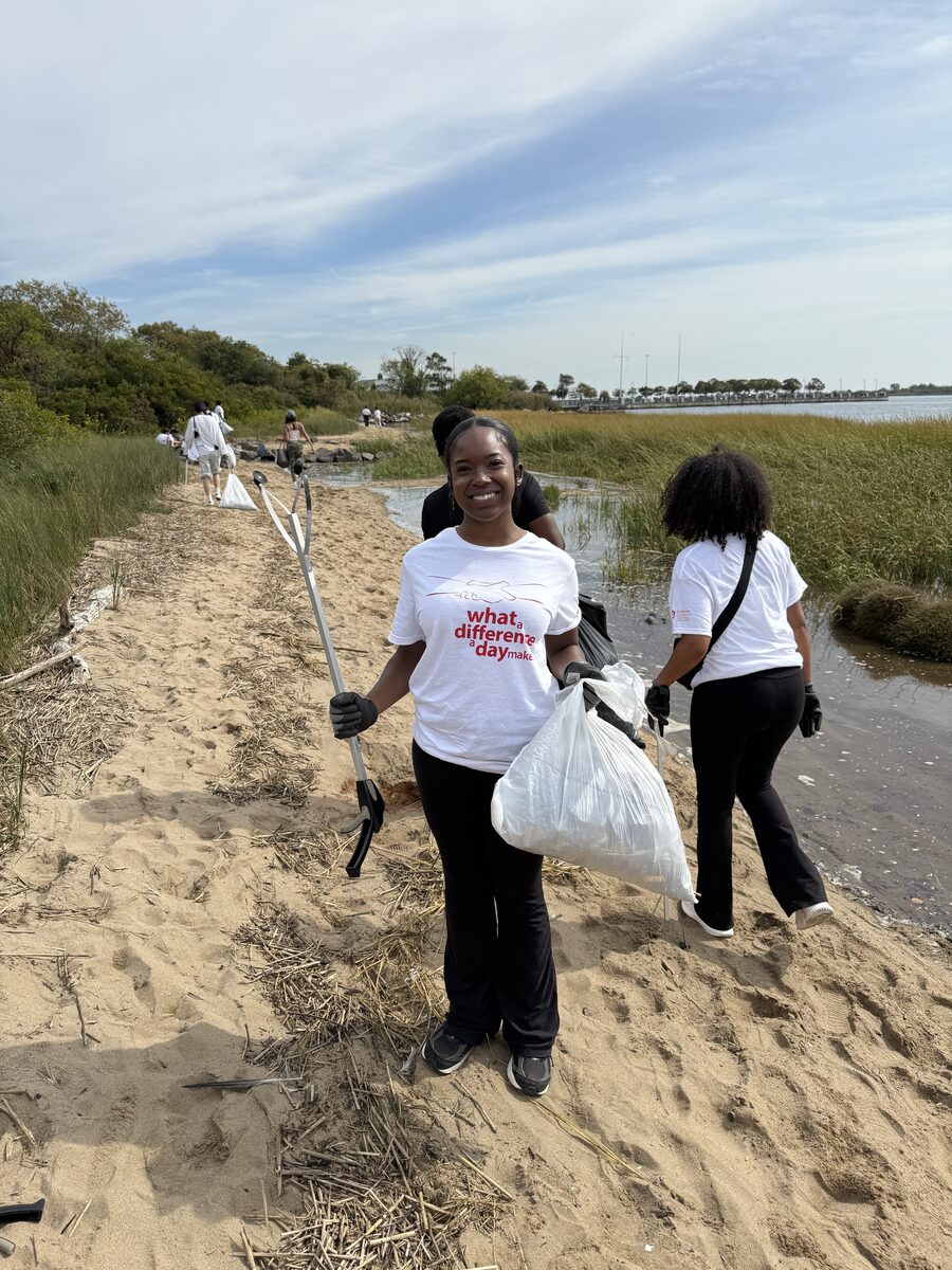 A scholarship recipient taking part in a community service beach cleanup